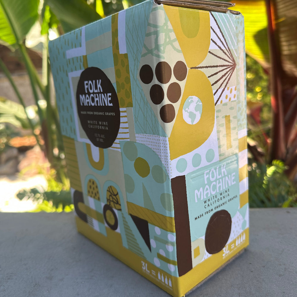 Decorative box with geometric design on a surface with plants in the background