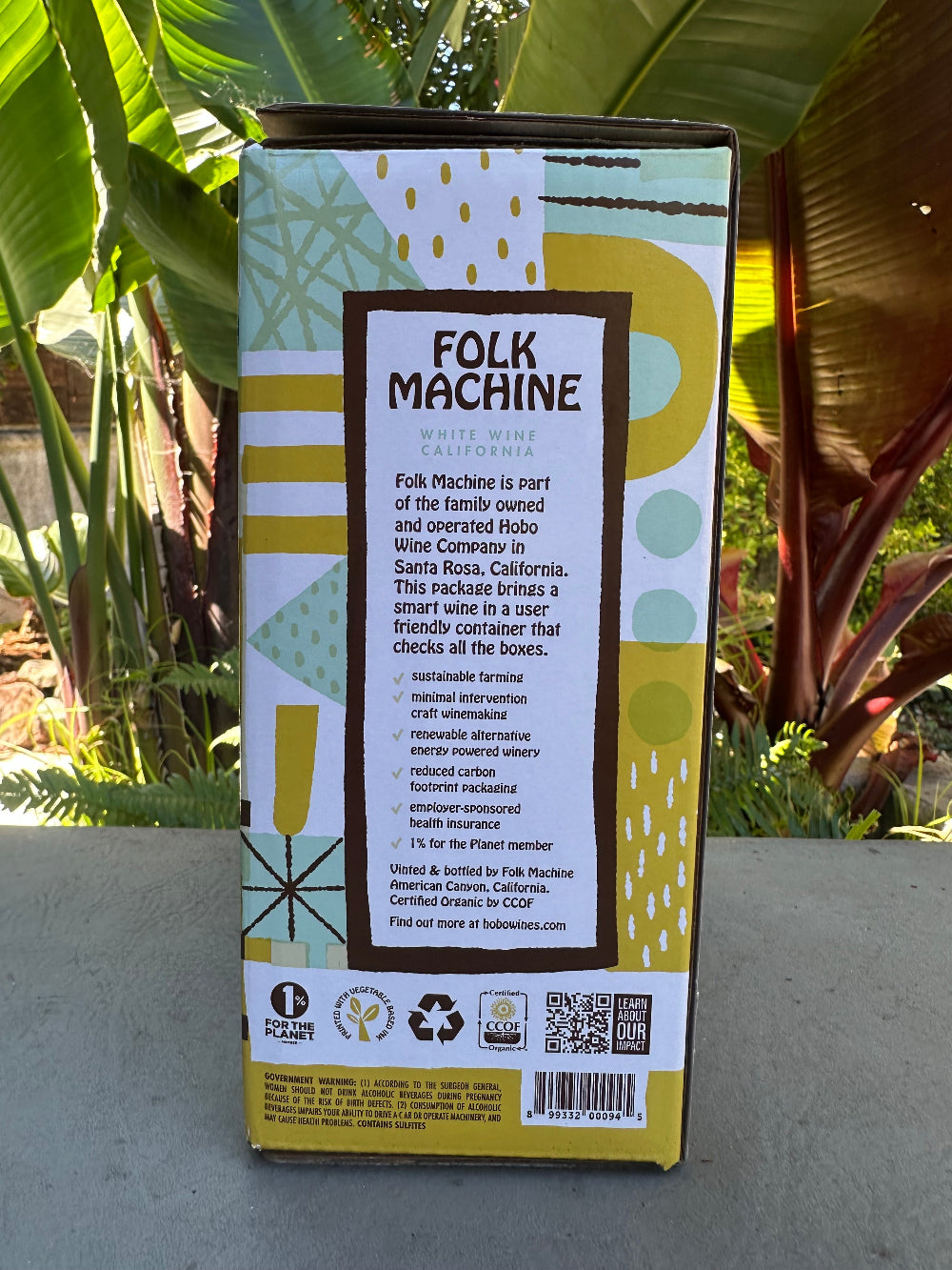 Box with 'Folk Machine' branding on a concrete surface with plants in the background